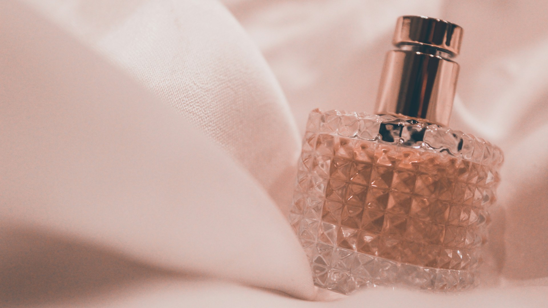 A bottle of salon grade hair oil on soft fabric